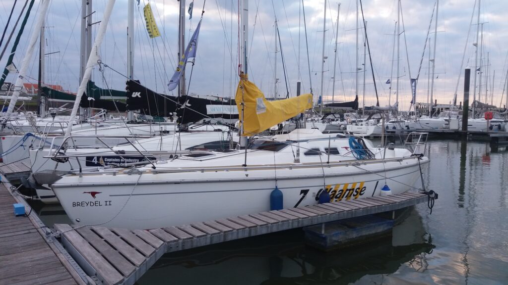Segelboote im Yachthafen; vorn liegt das weiße Boot „Breydel II“ mit gelbem Segelsack am Steg.
