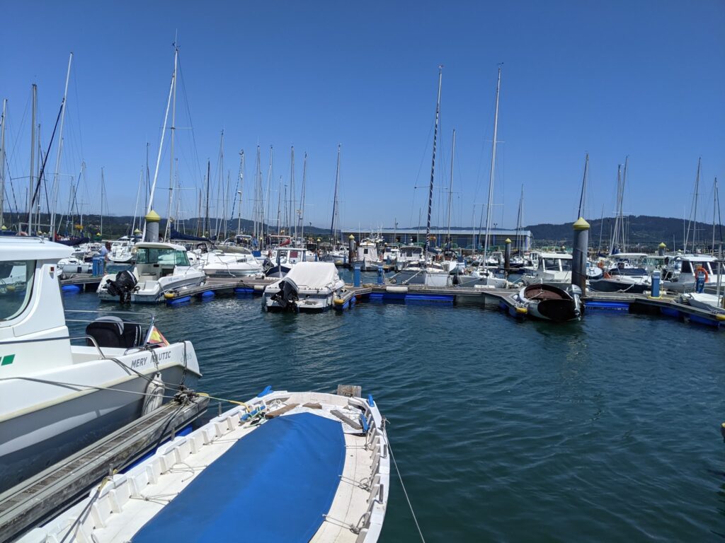 Yachthafen voller Segel- und Motorboote an Stegen; ruhiges Wasser unter strahlend blauem Himmel